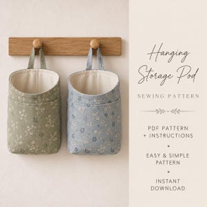 May include: Two fabric hanging storage pods with a floral pattern, one in sage green and one in dusty blue, suspended from a wooden wall hook. Text reads: Hanging Storage Pod SEWING PATTERN, PDF PATTERN + INSTRUCTIONS, EASY & SIMPLE PATTERN, INSTANT DOWNLOAD.