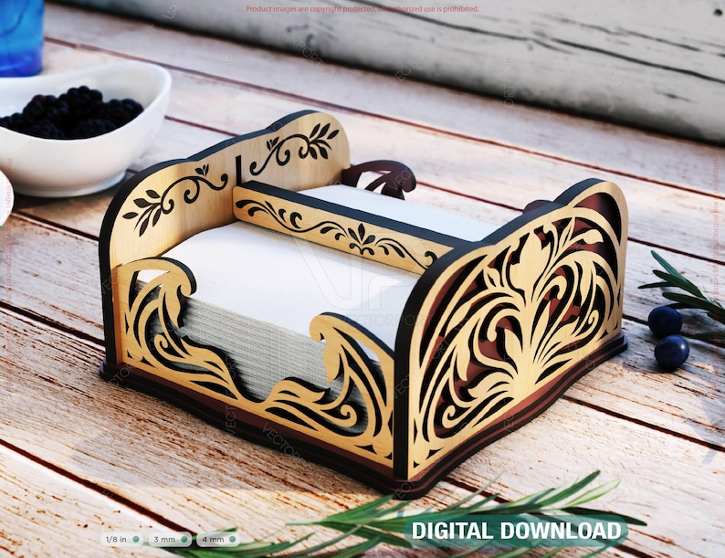Pu&ograve; includere: Un portatovaglioli decorativo in legno con intricati disegni traforati. Il supporto presenta una combinazione di colori marrone chiaro e scuro con motivi floreali e a onde. Contiene tovaglioli bianchi e poggia su una superficie di legno. Il testo "DIGITAL DOWNLOAD" &egrave; visibile.