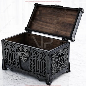 May include: A dark wooden chest with an open lid, revealing a dark interior. The exterior features intricate gothic-style cutouts and a pentagram design. The chest is black with a dark brown interior.