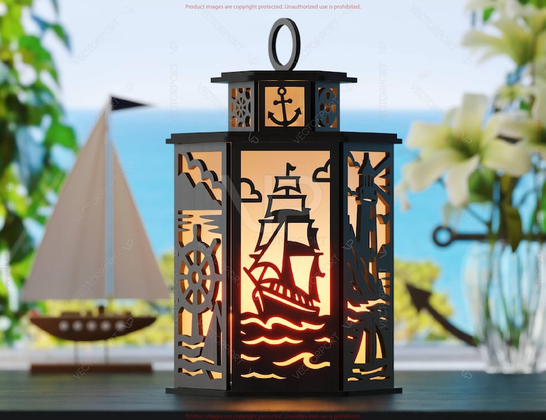 May include: Black nautical lantern with cut-out designs of a ship, anchor, lighthouse, and steering wheel. The lantern has a handle and is illuminated from within, creating a warm glow. A sailboat model is in the background.
