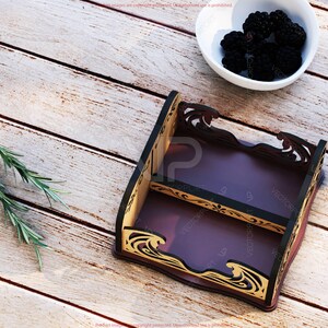 Pu&ograve; includere: Una mensola decorativa in legno a due livelli, con interno marrone scuro e finiture nere e dorate. La mensola &egrave; vuota e poggia su una superficie di legno chiaro. Una ciotola bianca di more e rametti di rosmarino sono nelle vicinanze.