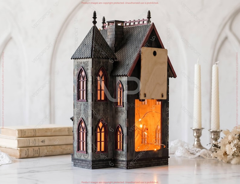 May include: A decorative, gray and red miniature haunted house with illuminated windows. The house features a detailed facade with arched windows and a wooden back panel. The interior glows with warm light, suggesting a cozy ambiance. The house is a unique Halloween or holiday decoration.