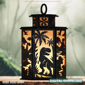 May include: Black laser-cut wooden lantern with a dinosaur theme. The lantern features a T-Rex silhouette, palm trees, and other prehistoric elements. The lantern has a handle and the words "DIGITAL DOWNLOAD".