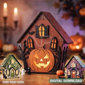 Puede incluir: Una gran decoración de casa encantada de madera marrón con una calabaza central, flanqueada por una casa verde más pequeña con motivos de fantasmas y una casa morada con lunas. El texto inferior dice DIGITAL DOWNLOAD, 1/8 in, 3 mm, 4 mm.