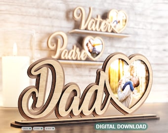 May include: Wooden cutout of the word "Dad" with a heart-shaped photo frame. The frame has a photo of a father and child. The word "Dad" is in a cursive font and the heart frame is on the right side of the word.