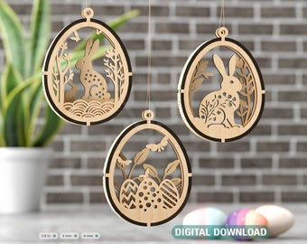 May include: Three wooden Easter egg ornaments with a laser cut design of bunnies and flowers. The ornaments are hanging from a string and are against a brick wall background.  DIGITAL DOWNLOAD