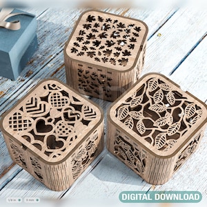 Könnte beinhalten: Drei Holzkisten mit aufwendigen Laser-Schnitzereien. Die Kisten sind quadratisch und haben eine hellbraune Oberfläche. Die Designs beinhalten Herzen, Blätter und geometrische Muster.