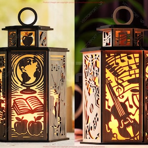 May include: A wooden lantern with intricate cut-out designs. One side features a globe, book, and apples, while the other showcases musical notes and instruments. The lantern has a ring handle and is illuminated from within.