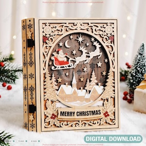 May include: A multi-layered wooden box featuring a laser-cut Christmas scene with Santa in a red sleigh pulled by reindeer, a village with snow-covered houses, and the text MERRY CHRISTMAS. The design includes stars, a moon, and snowflakes.