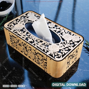 May include: A rectangular wooden tissue box with a floral design. The top and sides feature intricate laser-cut patterns of roses and leaves. The box is made of light-colored wood with a dark interior and a white tissue peeking out.