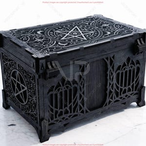 May include: A black wooden chest with intricate gothic and occult-inspired designs. The lid features a pentagram and celestial patterns. The sides have decorative cutouts and a pentagram. The chest has a rectangular shape and is elevated on small feet.