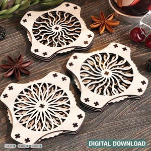 May include: Three wooden coasters with intricate laser-cut designs. Each coaster features a circular pattern with a starburst effect in the center. The coasters are stacked on top of each other, with the top coaster slightly offset from the bottom two. The coasters are made of light-colored wood and have a natural finish.