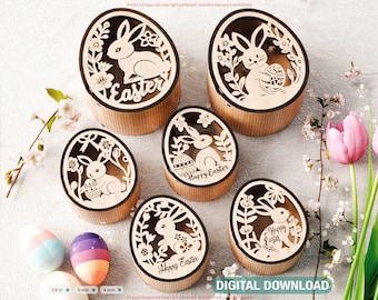 May include: Six wooden egg-shaped boxes with laser-cut designs of bunnies and flowers. The boxes are decorated with the words "Easter" and "Happy Easter".