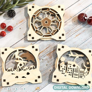 May include: Three wooden laser cut ornaments with intricate designs. The first ornament features a geometric pattern, the second a surfer riding a wave with a dolphin, and the third a cityscape with a plane flying overhead.  The ornaments are on a light wood background.