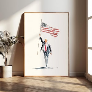 May include: Watercolor painting of a person in a suit holding the American flag aloft. The artwork is framed in a wooden frame and leans against a wall. The painting is in a room with a plant and a window.