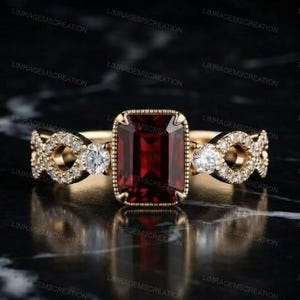 Anello di fidanzamento con granato rosso taglio smeraldo, anello con castone in oro giallo e lavorazione milgrain, anello vintage Art Déco con fascia infinito, anello di promessa con gemma rosso rubino.