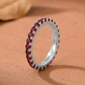 Könnte beinhalten: Eine weiße Keramik-Tasse mit schwarzem Henkel und dem Text "But First, Coffee" in schwarzer, fetter Schrift. Die Tasse steht auf einer weißen Oberfläche.