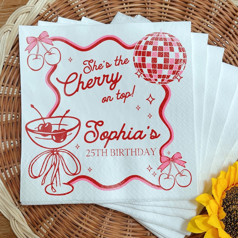 May include: White paper napkins with a red and pink design. The design includes cherries, a disco ball, and the text "She's the Cherry on top! Sophia's 25th Birthday."