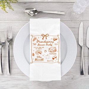 May include: White Friendsgiving dinner party napkin with a brown decorative border and illustrations of food and drinks. The text includes "Friendsgiving Dinner Party", "Let's Eat, Drink, and Be Thankful!", "The Bennett", and the date 10.29.2025.