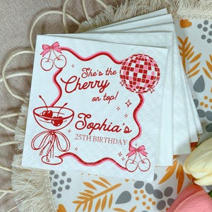 May include: White paper napkins with a red and pink cherry design. The napkins feature the text "She's the Cherry on top! Sophia's 25th Birthday" with a disco ball and cherry illustrations.