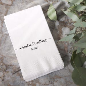 May include: White paper napkins with the text "amanda & anthony" and the date "10.29.25" printed in black ink.