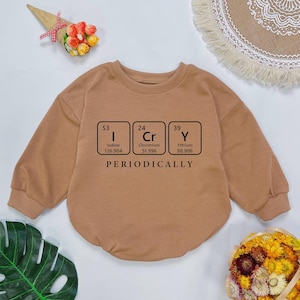 May include: A brown long-sleeved sweatshirt with a graphic of three periodic table elements: Iodine (I), Chromium (Cr), and Yttrium (Y). The text "PERIODICALLY" is printed below the elements.