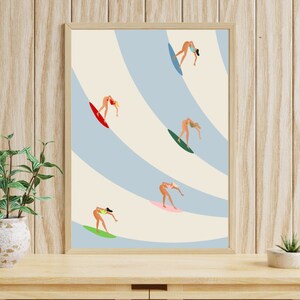 May include: A framed illustration of five figures surfing on blue and white waves. The figures are all women wearing bikinis and are in various poses on their surfboards.