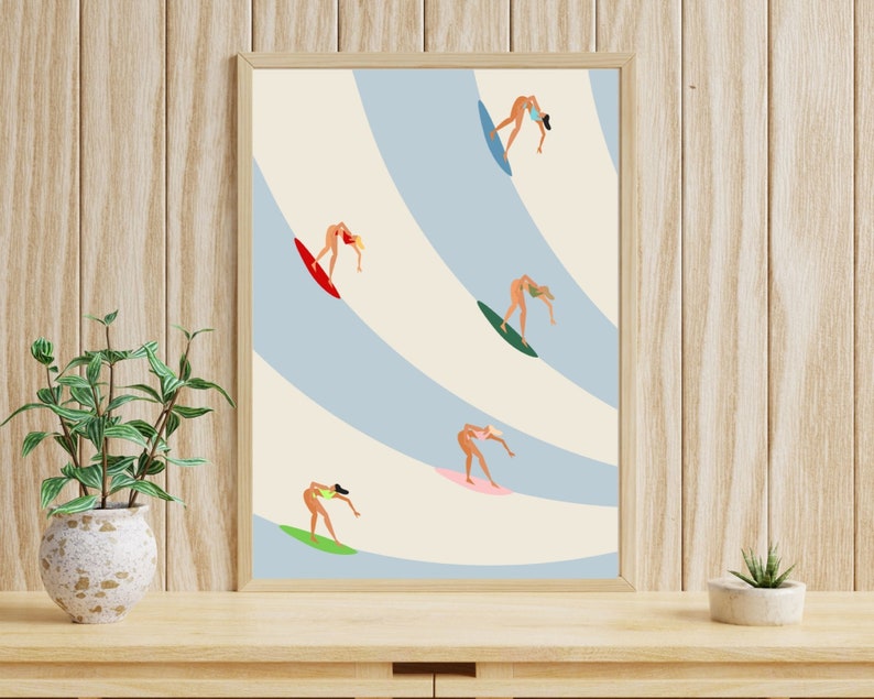 May include: A framed illustration of five figures surfing on blue and white waves. The figures are all women wearing bikinis and are in various poses on their surfboards.