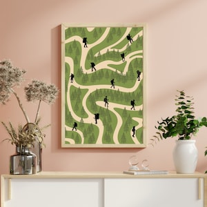 May include: A framed print with a green and cream background featuring a winding path through a forest. Silhouettes of hikers are walking along the path.