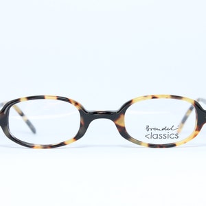 Könnte beinhalten: Ovale Brille aus Schildpatt mit klaren Gläsern. Der Markenname "Breudel Classics" ist auf dem rechten Glas aufgedruckt.