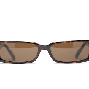 May include: Tortoiseshell sunglasses with brown lenses. The sunglasses have a rectangular shape.