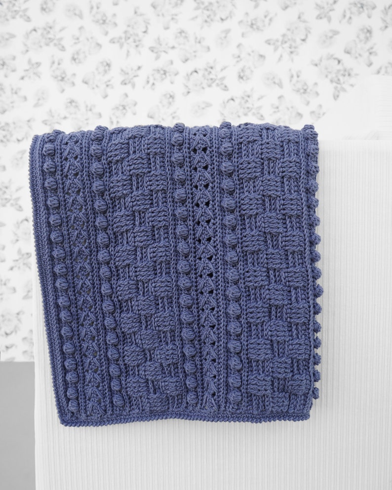 May include: A blue crocheted blanket with a textured pattern and a fringe border.