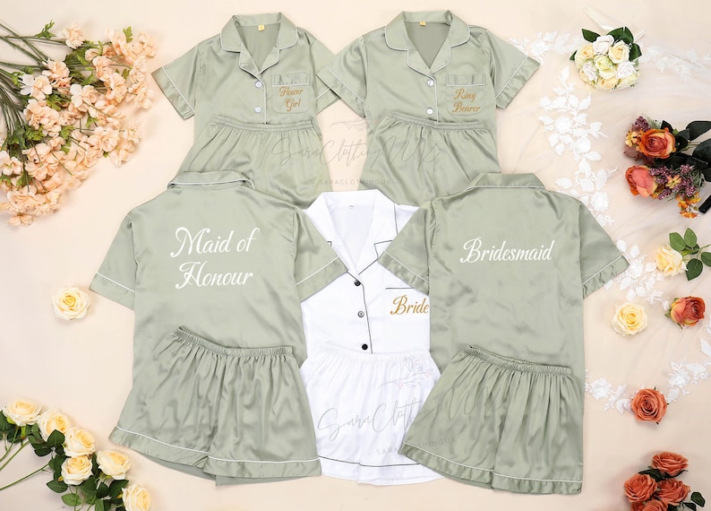 May include: Five satin pajamas in various shades of green and white with embroidered text. The text reads "Flower Girl", "Ring Bearer", "Maid of Honour", "Bride", and "Bridesmaid".