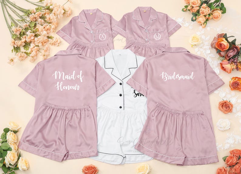 May include: A collection of satin pajama sets in pink and white. The pink sets have "Maid of Honour", "Bridesmaid", and initial monograms on the shirts. The white set has black trim and the name "Sara".