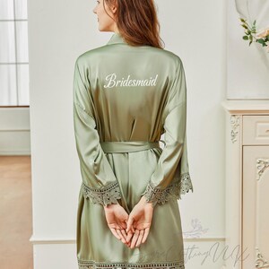 May include: Sage green satin robe with lace trim and the word "Bridemaid" embroidered on the back.