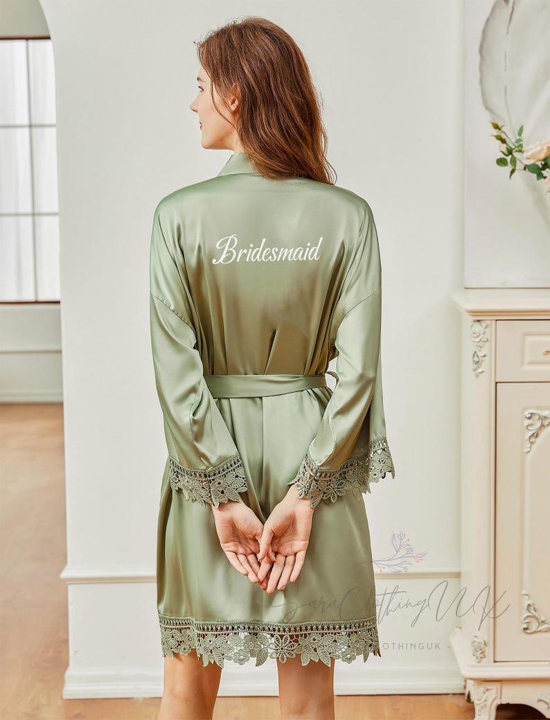 May include: Sage green satin robe with lace trim and the word "Bridemaid" embroidered on the back.