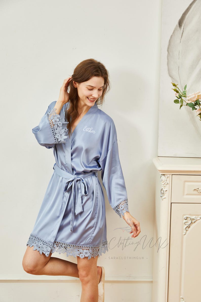 May include: A light blue satin robe with lace trim and a personalized embroidery that says "Esther".