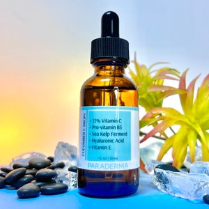 May include: A brown glass bottle with a dropper top containing a serum labeled "Cucumber C Drops". The bottle is labeled with the ingredients: 15% Vitamin C, Pro-vitamin B5, Sea Kelp Ferment, Hyaluronic Acid, Vitamin E. The bottle is labeled "PARADERMA" and "1 FL OZ | 30 ml".