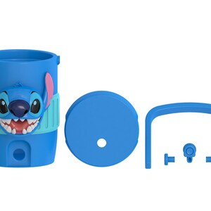 May include: A blue plastic tumbler featuring a raised Stitch character face with pink ears and a wide grin. The set includes a matching blue circular lid with a center hole, a blue arched handle, and three small blue components for assembly.