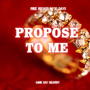 May include: A gold ring with multiple clear gemstones, set against a red background. The text "PROPOSE TO ME" is prominently displayed in white, with additional text indicating "FREE RECAST IN 30 DAYS" and "SAME DAY DELIVERY".