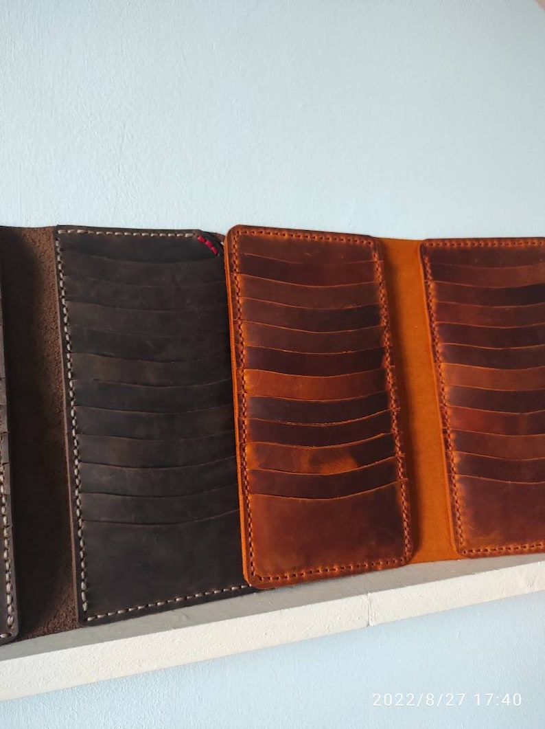 May include: Three leather wallets with multiple card slots. The wallets are brown, dark brown, and orange.