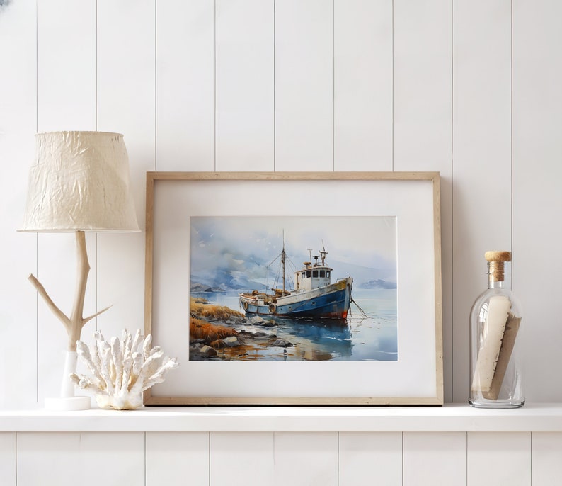 May include: A framed watercolour painting of a blue and white fishing boat moored in a harbour. The boat is surrounded by water and a rocky shore. The painting is set against a backdrop of a cloudy sky.