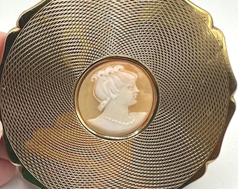 Exclusivo estuche de polvos de maquillaje Stratton Cornalina con camafeo tallado en tono dorado.