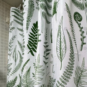May include: White shower curtain with a green fern pattern. The ferns are printed in a botanical style.