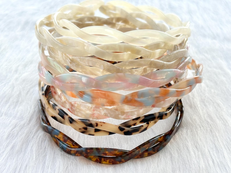 Puede incluir: Un conjunto de seis diademas de pl&aacute;stico trenzadas en varios colores y patrones, incluyendo carey, blanco y rosa.