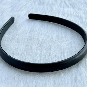 May include: A black headband made of a smooth, flexible material.