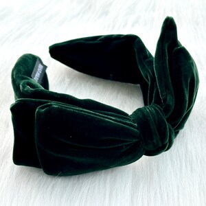Puede incluir: Diadema de terciopelo verde oscuro con un lazo anudado. La diadema est&aacute; hecha de un material suave y afelpado. La etiqueta dice "HAND MADE". Un accesorio para el cabello.