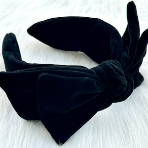 Puede incluir: Una diadema de terciopelo negro con un lazo anudado. La diadema est&aacute; hecha de terciopelo suave y presenta una banda ancha y un lazo grande en la parte delantera. Este accesorio est&aacute; dise&ntilde;ado para ser usado en la cabeza.