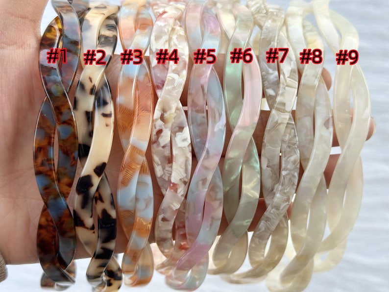 Puede incluir: Nueve diademas trenzadas de pl&aacute;stico para el cabello en varios colores y patrones, incluyendo carey, marr&oacute;n, blanco e iridiscente. Las diademas est&aacute;n numeradas del 1 al 9.