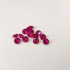 Może przedstawiać: Grupa małych, okrągłych, różowych kamieni szlachetnych. Kamienie szlachetne są fasetowane i mają błyszczące, wypolerowane wykończenie.